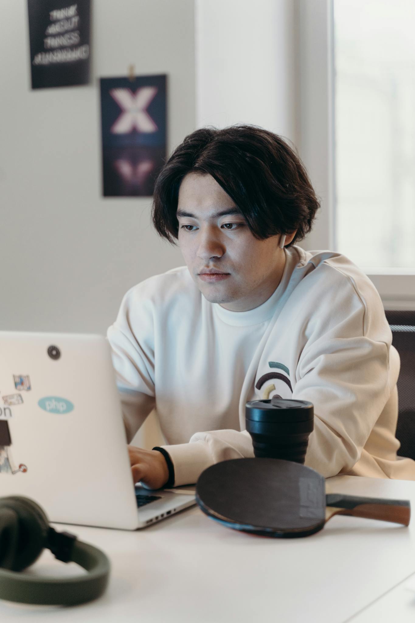 An adult working on a laptop in a modern office setup, showcasing concentration and productivity.